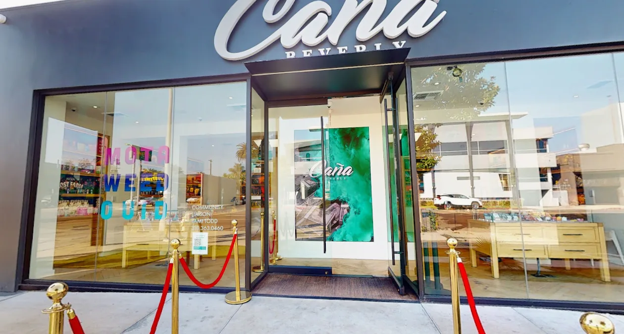 The entrance at Caña Beverly, gold stanchions and a red rope beside the green marbled door