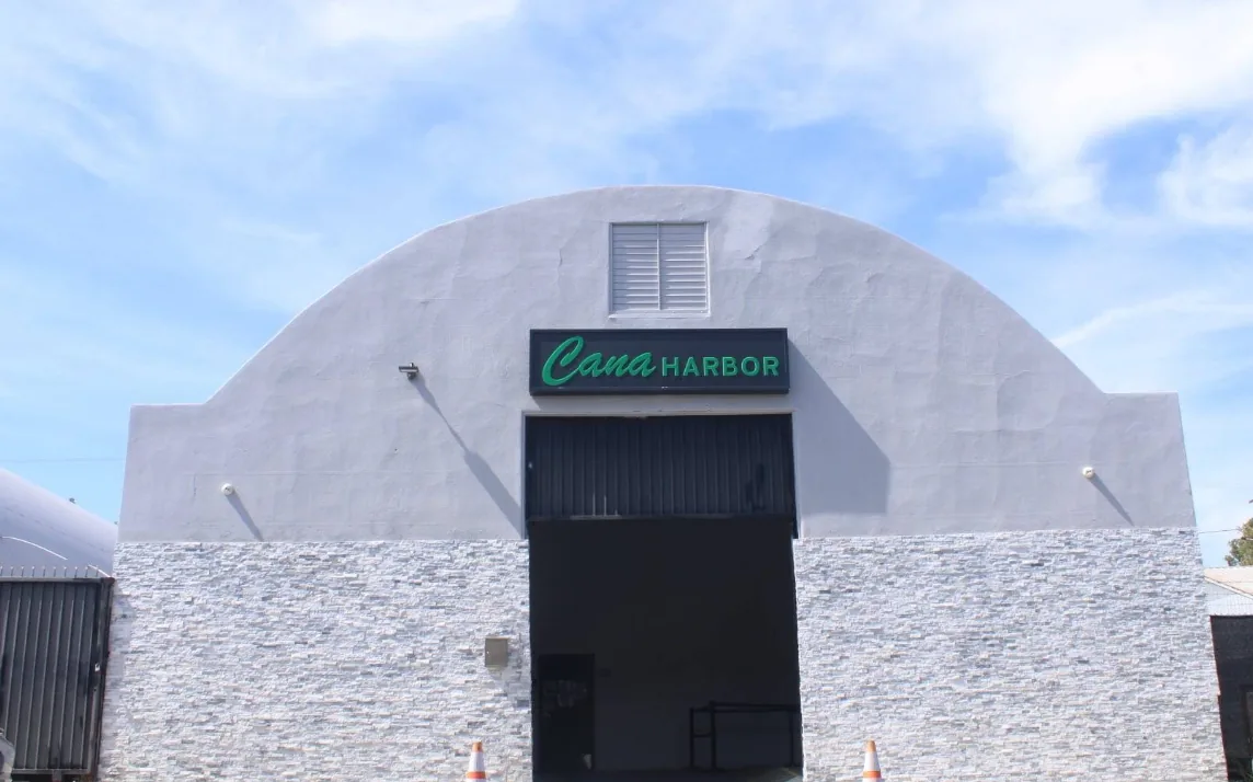 The arched white storefront at Caña Harbor City on W 253rd St